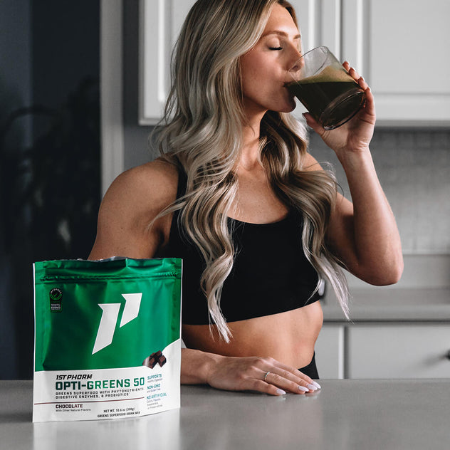 female in kitchen drinks greens superfood